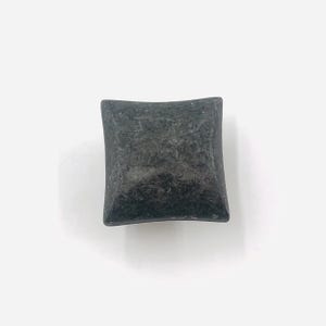 May include: A square cabinet knob with a dark charcoal grey finish and a textured, slightly mottled surface. The knob features a pyramid-like shape with four sloping sides that meet at a central point, creating a distinct geometric profile.