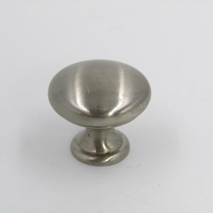 May include: A silver cabinet knob with a round, slightly domed top and a short, cylindrical base.