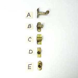 Op de afbeelding: Een assortiment van vijf antieke messing hardware-onderdelen, gelabeld A t/m E, verticaal gerangschikt op een witte achtergrond. De hardware omvat verschillende grendels en scharnieren, met verschillende ontwerpen en maten. De onderdelen vertonen tekenen van slijtage.
