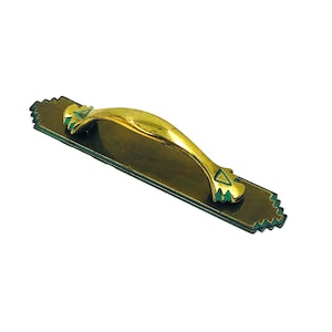 Puede incluir: Un tirador de puerta de latón con un asa curvada y una placa trasera rectangular. El asa es dorada, y la placa trasera es de latón más oscuro con detalles verdes y un borde decorativo. Diseño vintage.