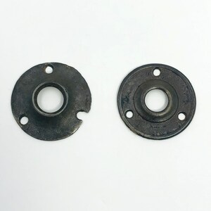 以下が含まれることがあります： 暗く古びた仕上がりの、2つのアンティークの円形金属プレート。各プレートには中央の穴と周囲に小さな穴があります。1つのプレートには、端に小さな切り欠きがあります。これらのプレートは、ハードウェアコンポーネントである可能性があります。