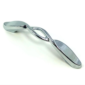 May include: A polished chrome cabinet pull with a unique, twisted design. The handle features a central open oval and elongated, rounded ends. This decorative hardware adds a modern touch to furniture.