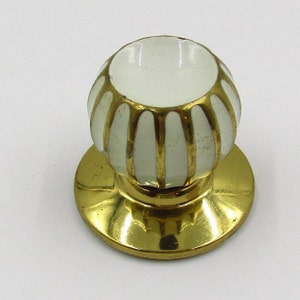 Peut inclure: Bouton de porte en céramique blanche avec une garniture dorée et une base en laiton.