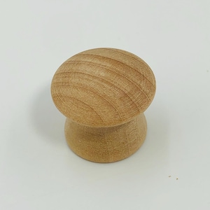 Può includere: Un pomello per mobili in legno con una parte superiore arrotondata e una base cilindrica. Il pomello è realizzato in legno chiaro, che mostra il motivo naturale della venatura. Il pomello è progettato per cassetti o armadi.