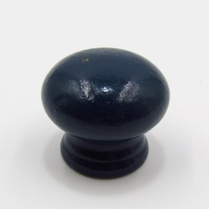 以下が含まれることがあります： 丸みを帯びたトップとわずかに広がったベースを持つ濃い青色の木製ノブ
