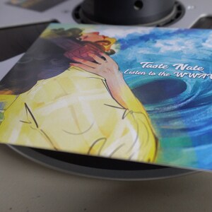Op de afbeelding: Een blauwe en groene aquarel albumhoes met een stel dat elkaar omhelst. De tekst op de hoes luidt "Taste Nate listen to the WWWVV".