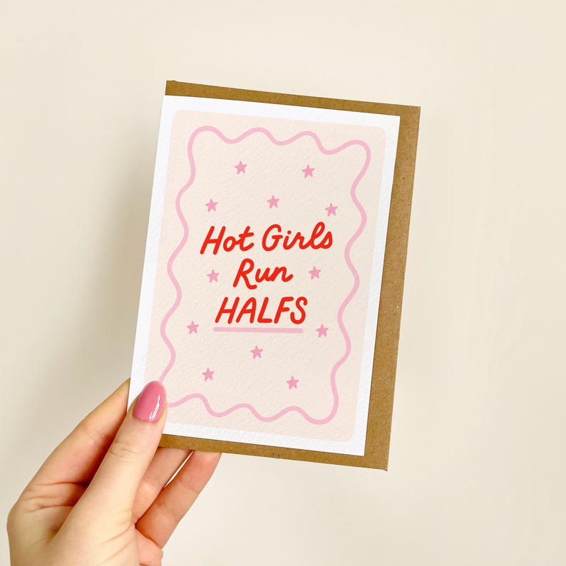 May include: A greeting card with a brown border and a light pink background. The card features the text "Hot Girls Run Halfs" in red, with pink stars and a wavy pink border.