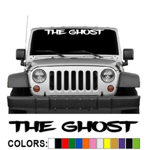 May include: A silver Jeep with the text "THE GHOST" across the top of the windshield. Below the Jeep, the same text is repeated, along with a color palette of available options.