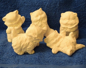 May include: Five white ceramic cat figurines in various poses. The cats are all in a playful or relaxed position.