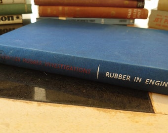 May include: A blue hardback book titled "Rubber in Engineering" with the words "Firestone Tyres Rubber Investigations" printed on the spine.