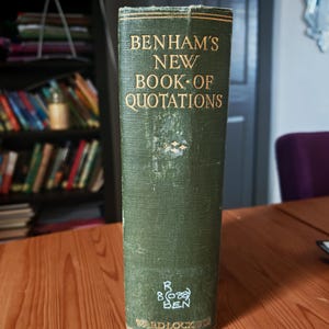 May include: A green hardcover book titled Benham's New Book of Quotations with gold lettering on the spine. The spine features a small diamond-shaped decorative element, white handwritten library classification text, and the publisher name Ward Lock.