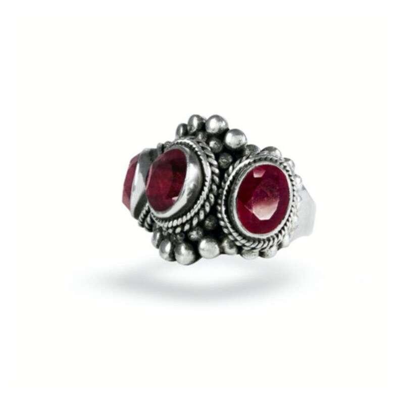 May include: A silver ring with three red gemstones set in ornate silver settings. The ring has a textured band and a decorative design.