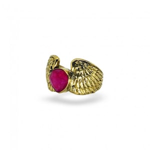 Puede incluir: Anillo de oro con una piedra preciosa rosa engastada en el centro y dos alas a cada lado.