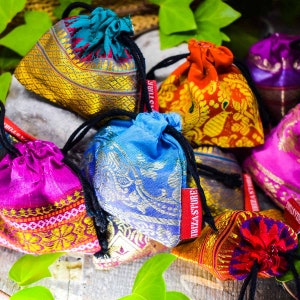 Puede incluir: Surtido de bolsitas de cord&oacute;n de colores con intrincados patrones y detalles dorados. Las bolsitas est&aacute;n hechas de seda y tienen un cierre de cord&oacute;n negro. Las bolsitas est&aacute;n etiquetadas con el texto "Ibiza Store".