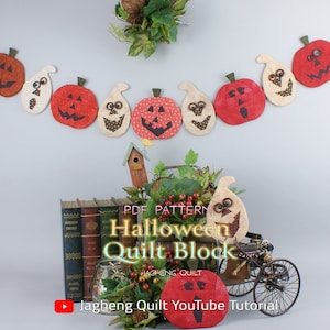 Peut inclure: Un motif de bloc de courtepointe d'Halloween avec une guirlande de visages de citrouilles et de fantômes. Le motif est disponible en téléchargement PDF. L'image comprend également un petit nichoir en bois, une voiture ancienne et une pile de livres. Le texte sur l'image est "PDF PATTERN Halloween Quilt Block JagHeng Quilt JagHeng Quilt YouTube Tutorial".