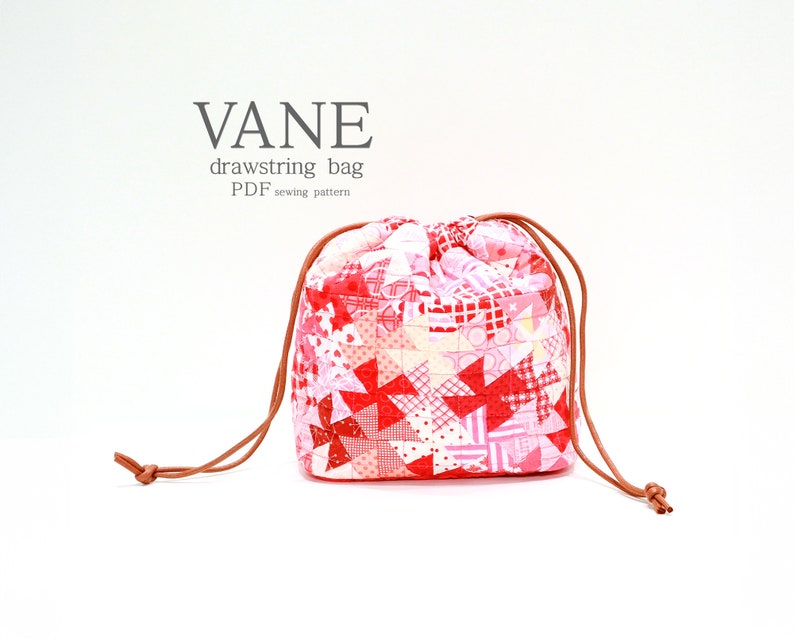 K&ouml;nnte beinhalten: Ein rot-rosa Patchwork-Beutel mit Kordelzug und brauner Kordel. Der Beutel ist mit geometrischen Formen und floralen Motiven gemustert. Der Text "VANE drawstring bag PDF sewing pattern" ist &uuml;ber dem Beutel zu sehen.