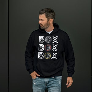 May include: A black hooded sweatshirt with a white graphic design featuring the word "BOX" repeated three times, each with a different tire design.