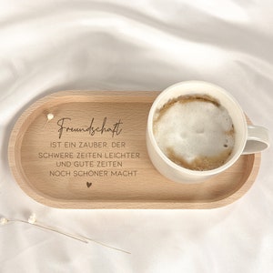 May include: A wooden tray with a white coffee cup and the text "Freundschaft ist ein Zauber, der schwere Zeiten leichter und gute Zeiten noch sch&ouml;ner macht".