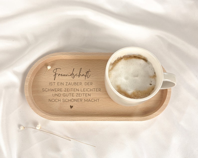 May include: A wooden tray with a white coffee cup and the text "Freundschaft ist ein Zauber, der schwere Zeiten leichter und gute Zeiten noch sch&ouml;ner macht".