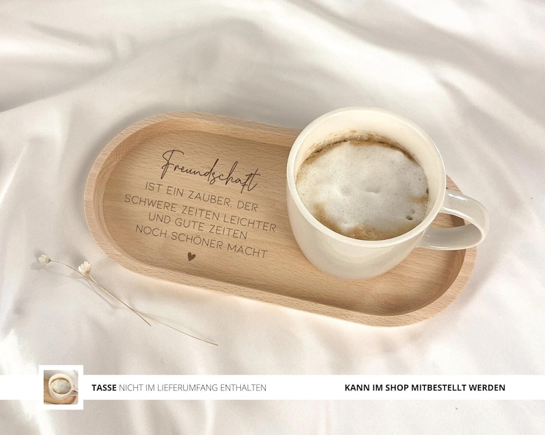 May include: A wooden tray with a quote about friendship engraved on it. The quote reads "Friendship is a magic that makes hard times easier and good times even better." The tray has a white ceramic mug with coffee on it.