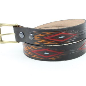 May include: A brown leather belt with a brass buckle and a geometric pattern in red, orange, and blue.