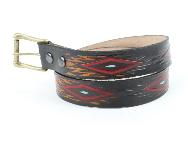 May include: A black leather belt with a geometric pattern in red, orange, and blue. The belt has a brass buckle.