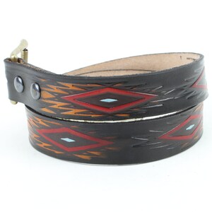 May include: A black leather belt with a geometric pattern in red, orange, and blue. The belt has a silver buckle.