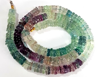 May include: A strand of multi-colored fluorite beads. The beads are faceted and have a variety of shades of green, purple, and blue. The beads are strung on a silver wire.