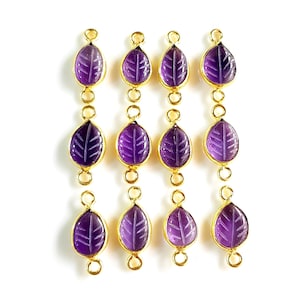 Può includere: Nove ciondoli dorati a forma di foglia con pietre di ametista. Ogni ciondolo ha due anelli a salto per fissarlo a gioielli.