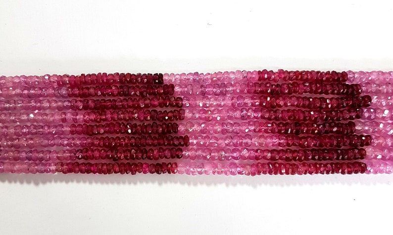 May include: A strand of pink and red faceted gemstone beads. The beads are small and have a slightly irregular shape. The strand is approximately 16 inches long.