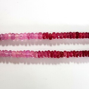 May include: Two strands of pink and red gemstone beads. The beads are faceted and have a graduated color from pink to red.