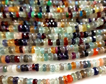 May include: Close-up of multiple strands of faceted gemstone beads in various colors. The beads include shades of green, blue, red, orange, and purple. The beads are strung together, creating a textured and colorful display.