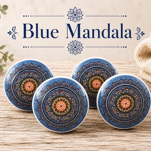 May include: Four blue and white ceramic cabinet knobs with a mandala design. The knobs feature a central orange and yellow floral pattern surrounded by intricate blue and white details. The text "Blue Mandala" is above the knobs.