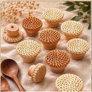 May include: A collection of wooden cabinet knobs with woven rattan tops in various shades of brown and beige. The knobs have a rounded shape and are displayed on a neutral-colored surface, showcasing their natural textures and design.