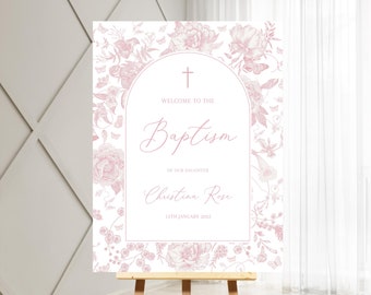 Pode incluir: Um cartaz de boas-vindas branco com desenhos florais rosa e uma cruz no topo. O texto diz "Bem-vindo ao Batismo de nossa filha Christina Rose 15 de janeiro de 2023".