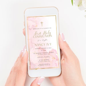 May include: Pink and gold digital invitation for a First Holy Communion celebration. The invitation features a watercolor background with gold accents and a cross. The text reads "First Holy Communion of our daughter Nancy Ivy" and includes the date, time, and location of the event.
