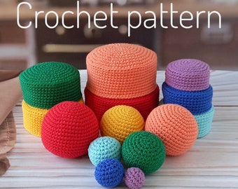 May include: A set of crocheted balls and cylinders in various colors, including red, green, yellow, blue, orange, and purple. The crocheted items are arranged on a wooden surface. The text "Crochet pattern" is visible at the top of the image.