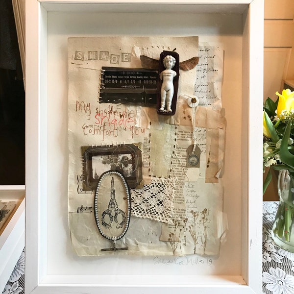 Mixed media collage. ‘My Shade Will Comfort You’. In white box frame.