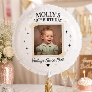 May include: A round white foil balloon featuring a central square photograph of a young child in a light green shirt. The text reads MOLLY'S 40TH BIRTHDAY and Vintage Since 1986. The design includes black star icons and faux tape accents.