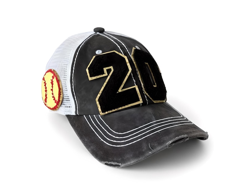 May include: A black baseball cap with a distressed finish, featuring the number 20 in black felt with gold trim on the front panels. The cap has a white mesh back, white stitching on the brim, and a circular yellow softball patch on the side.