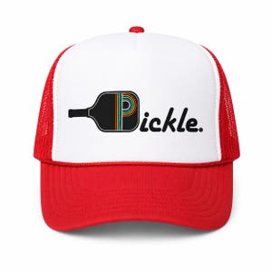 May include: A red and white trucker hat featuring a graphic of a black pickleball paddle with a rainbow-striped letter P inside the paddle head, followed by the black text pickle. The hat has a solid red brim and a white front panel.