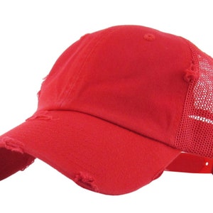 May include: A distressed red baseball cap with a curved peak and a mesh back. The cap has a worn, vintage appearance with frayed edges on the peak and crown. An adjustable strap is visible.