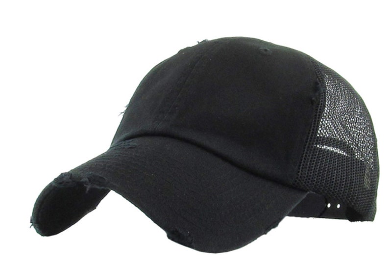 May include: Black baseball cap with a distressed peak and mesh back panel. The cap features a curved visor and a classic six-panel design. The fabric appears to be a soft cotton blend. The cap is a solid black colour.