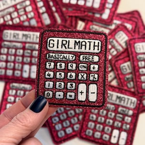 May include: A pink glitter calculator patch with the text "Girl Math" and the words "Basically Free" on the display. The calculator has the numbers 7, 8, 9, ON, +, 4, 5, 6, X, %, 1, 2, 3, +, -, 0, ., =, and -.