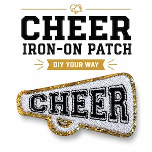 May include: An iron-on patch shaped like a megaphone with a white textured center and gold glitter border. The word CHEER is embroidered in black block letters across the center. Above the patch, the text reads CHEER IRON-ON PATCH and DIY YOUR WAY.