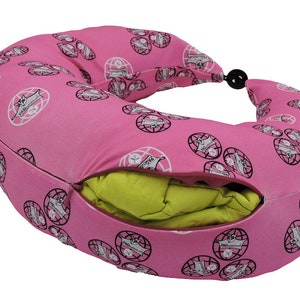 Op de afbeelding: Roze reisnek kussen met een ritsopening en een groen binnenkussen. Het buitenkussen heeft een herhalend patroon van globes met de tekst "PAD-a-go-go" op elke globe.