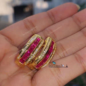 Peut inclure: Une paire de boucles d'oreilles créoles en or avec une double rangée de pierres carrées roses et une rangée de pierres claires plus petites.