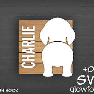 May include: A wooden sign with the name "CHARLIE" in white letters. The sign features a white silhouette of a dog's rear end with a leash hook.