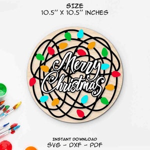 Puede incluir: Un letrero redondo de madera de 10,5 pulgadas con un texto en blanco y negro "Merry Christmas" rodeado de un diseño enredado de luces navideñas de colores.