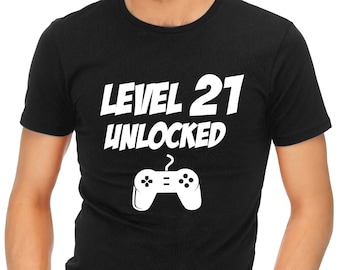 May include: Black t-shirt with white text that reads "Level 21 Unlocked" and a white video game controller graphic.